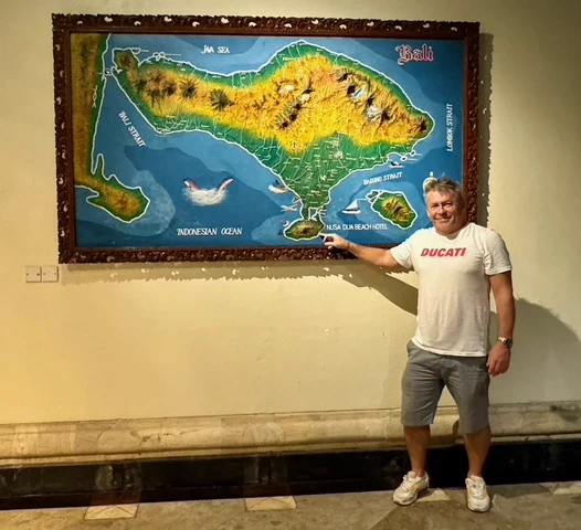 A traveller beside a large illustrated map of Bali