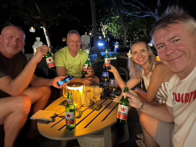 Four travellers sharing an evening at an outdoor table
