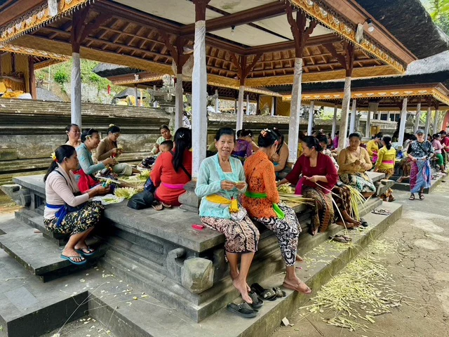People gathering beneath an open pavilion with traditional decorations