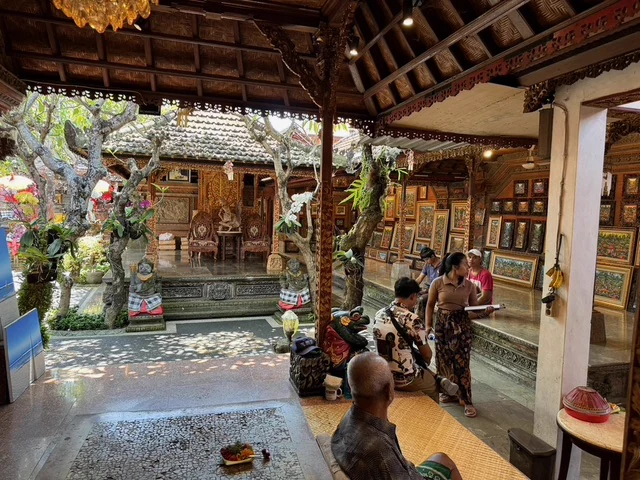 A sheltered courtyard with carved Balinese architecture and decorative offerings