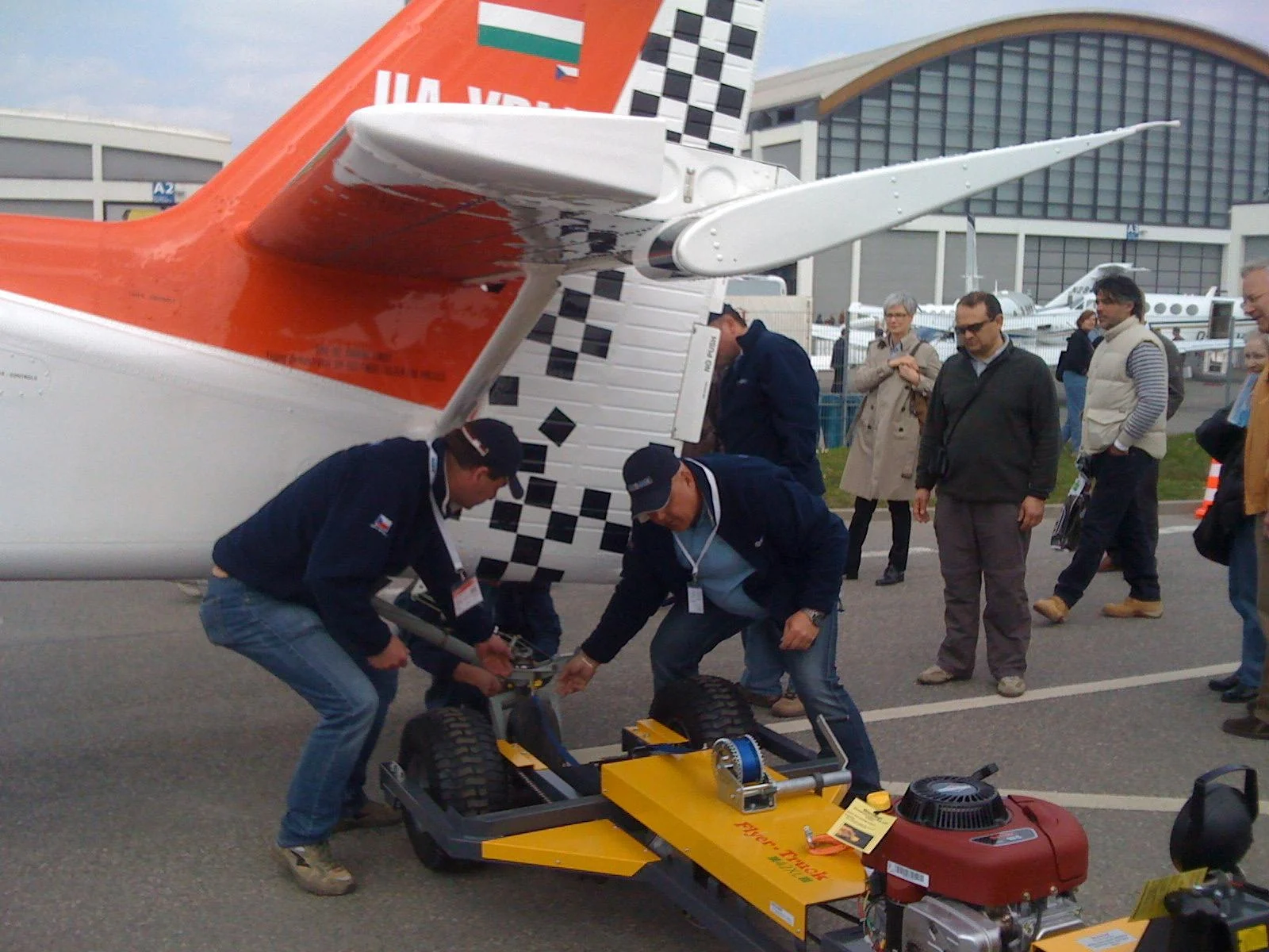 The aircraft tail and people beside ground-handling equipment