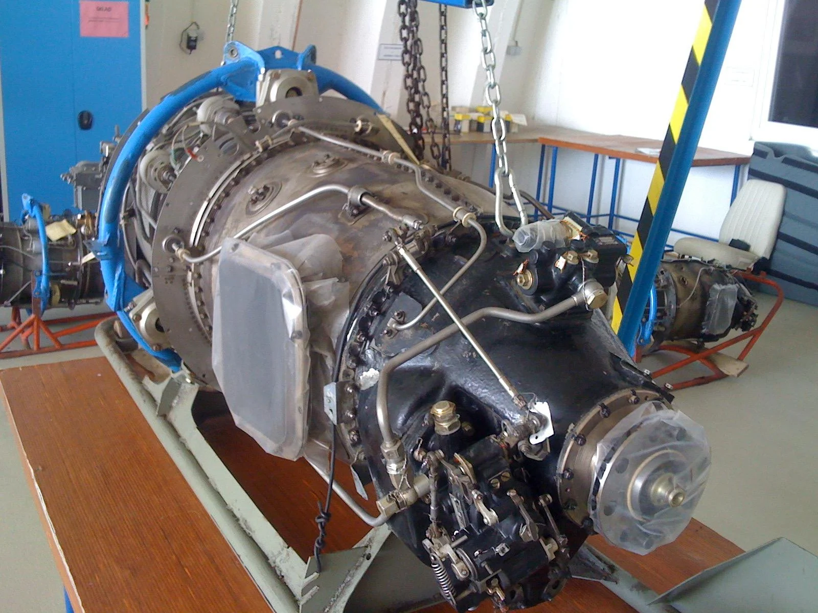 Close view of an engine casing, pipework and shaft in the workshop